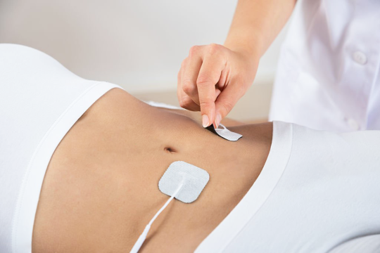 Electrode pads being applied, illustrating NMES technology
